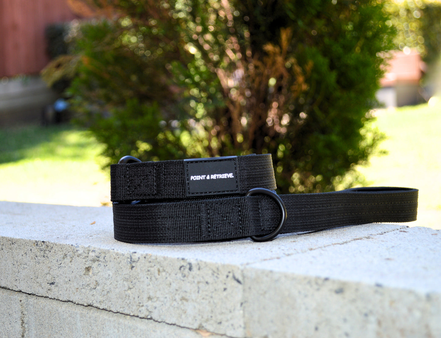 Black Tactical Lead on a concrete surface with a blurred outdoor background